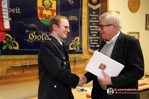 Bürgermeister Gustav Graf von Westarp (r.) überreicht die Urkunde zur Auszeichnung mit der Brandschutz-Ehrenspange des Innenministeriums für 10jährige Mitgliedschaft in der Feuerwehr an Florian Kahlert.